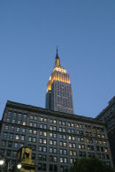 The Empire State Building in New York City, peeking over the top of another building.